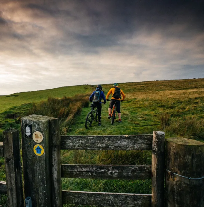 Two mountain bikers on a hillside trail.