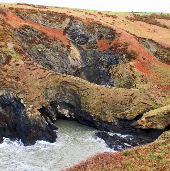 autumn colours on cliffs with caves and sea.