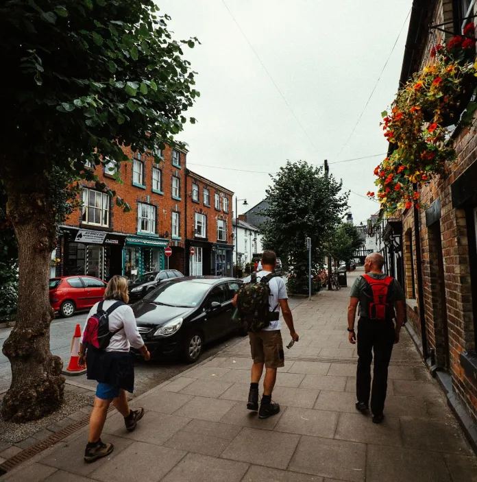 A few visitors walking with backpack's through a market town 