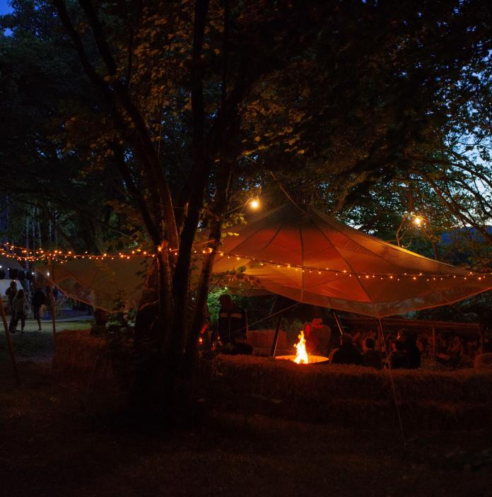 Festival at the tipi in the evening, with fairy lights.