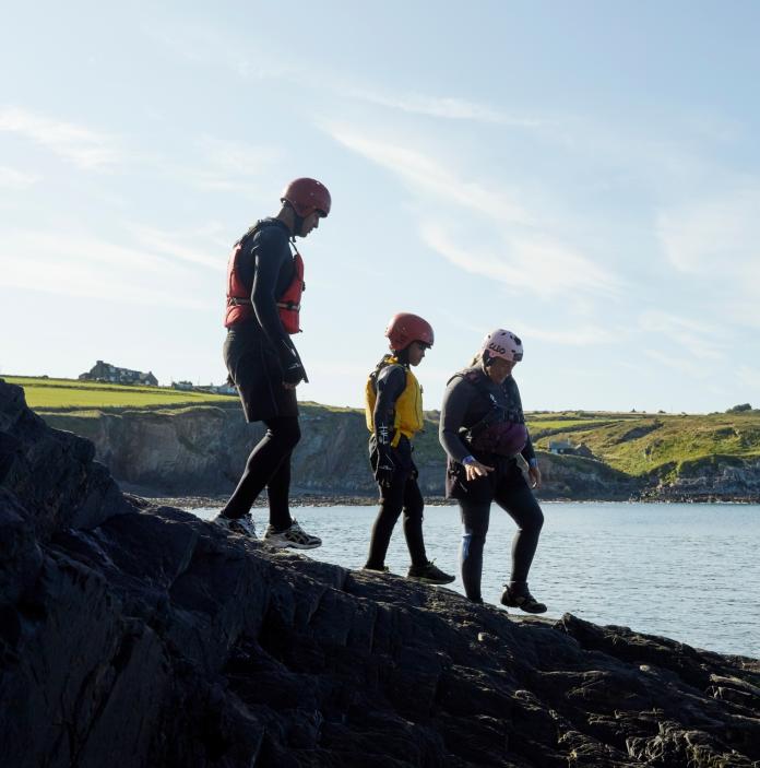 A group walking to coasteer in Abereiddy, Pembrokeshire.