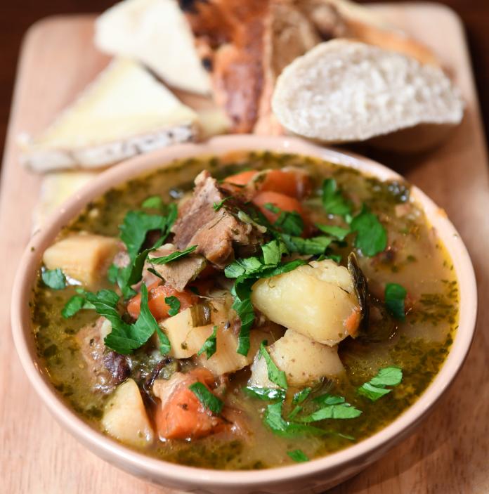 Cawl soup with bread on a wooden board