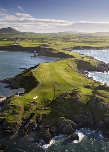 Aerial view of Nefyn golf course on a peninsula stretching out to sea