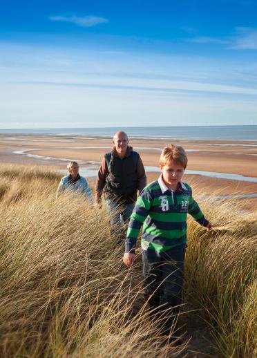 Family (parents and young son) walking Gronant Dunes