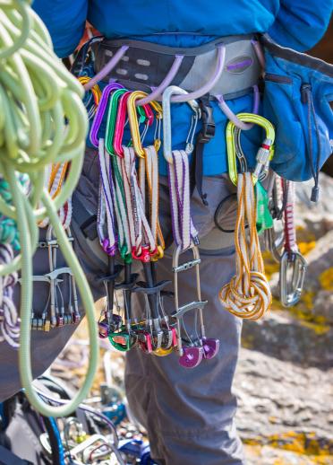 Ropes and other rock climbing equipment hanging form a person's harness
