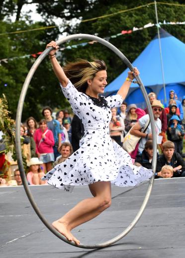 A woman in a rolling hoop on a stage.