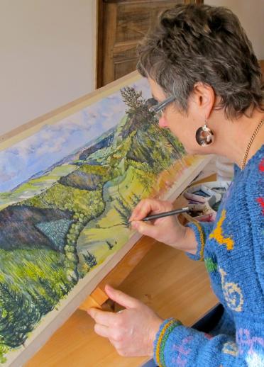 Painter Rosie Davies at work on a watercolour in her studio.
