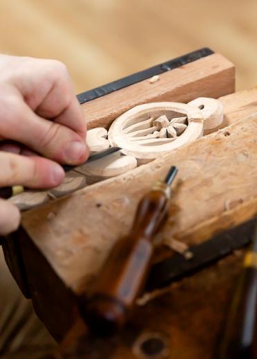 A wooden lovespoon in a vice being carved 