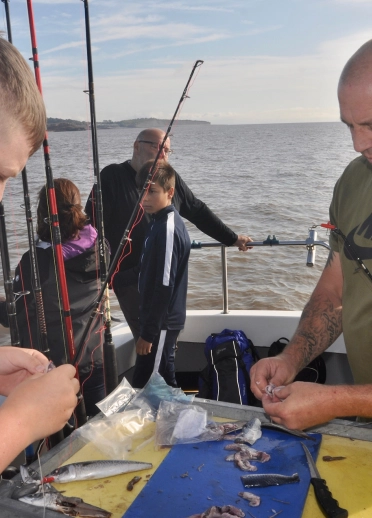 two males preparing fishing bait.
