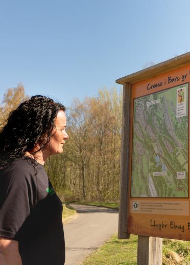 Woman looking at an information sign about Festival Park.