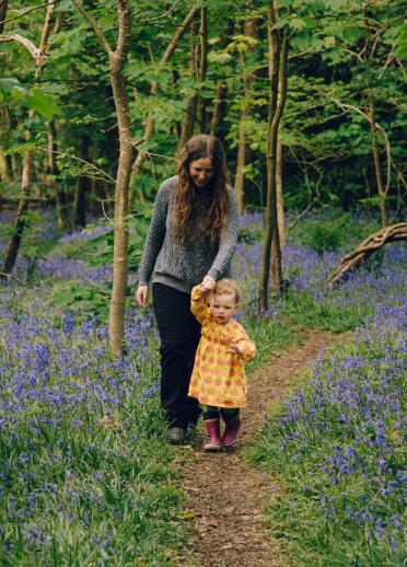 woman and toddler walking through blubell wood.