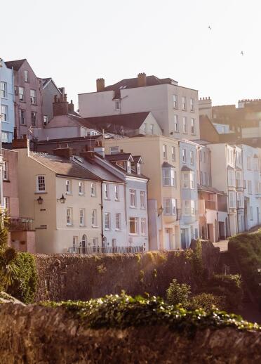 Row of tall houses with bay windows, behind the harbour wall in Tenby, Pembrokeshire.