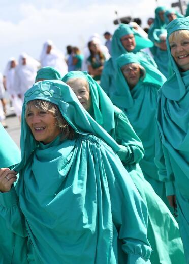 Eine Gruppe Frauen, die türkisblaue Gewänder tragen.