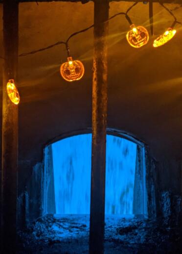 string of pumpkin lights inside dam tower.