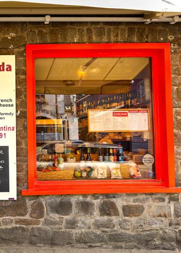 A food and drink shop with red doors and window frames.