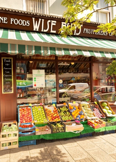 A shop with boxes of fruit and veg outside.