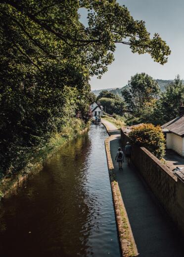 A canal with people walking along the towpath,