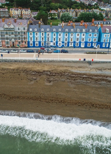 aerial view of different colour houses looking out to a beach and sea.