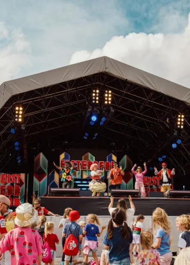 people, mostly children enjoying show on stage at Eisteddfod.