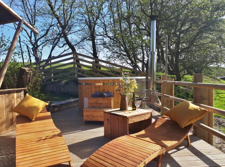 Wooden sun loungers and wood-fired hot tub out on the deck.