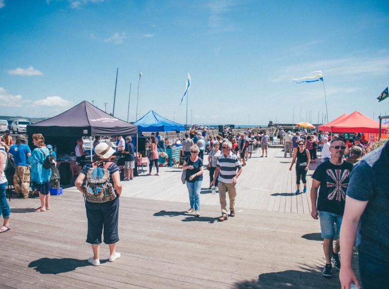 Stall holders and visitors along the jetty at Pembrokeshire Fish Week.