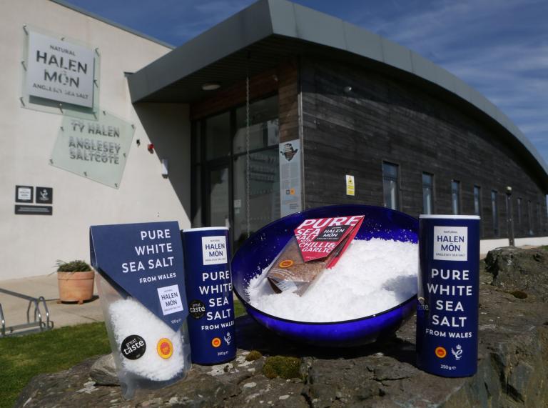 Some of the pure white sea salt products on display with Halen Môn Anglesey Sea Salt building in the background.