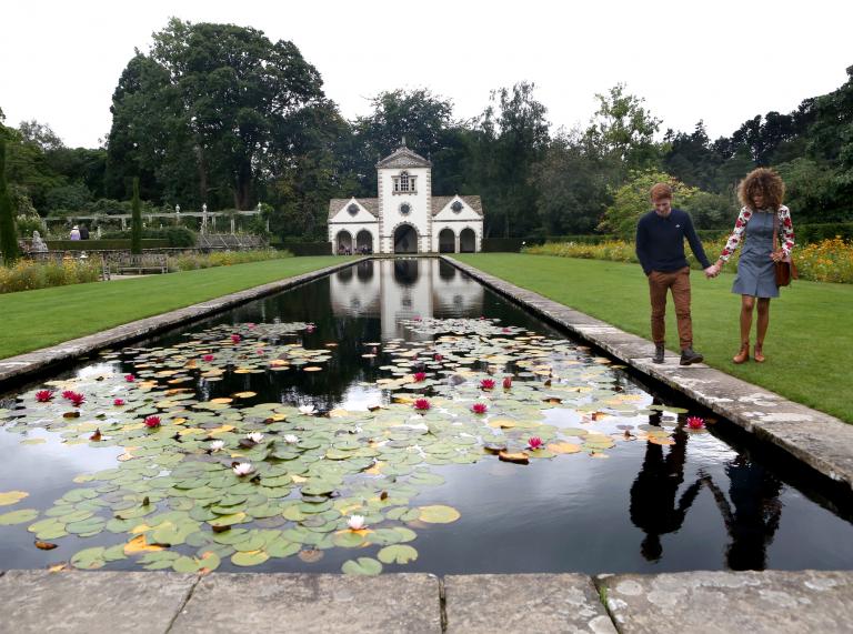 Image of a pond and couple walking at Bodnant Garden in Conwy, North Wales