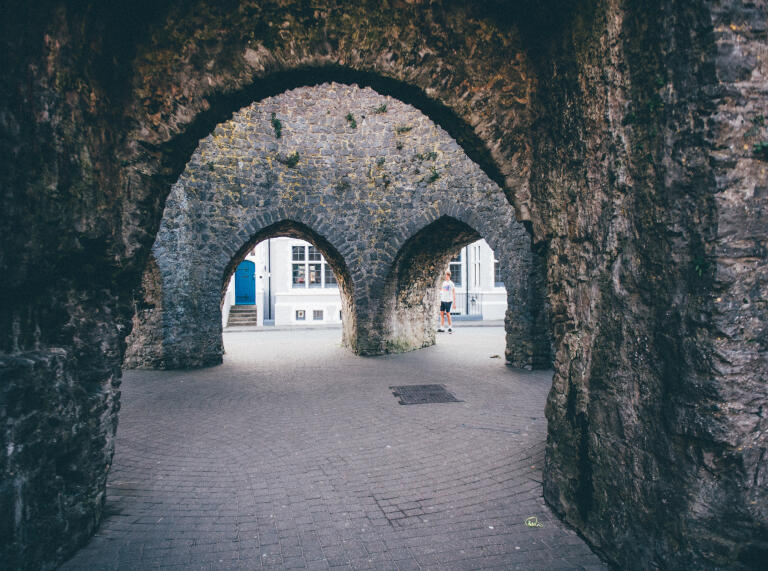 Ein steinernes Tor mit fünf Bögen als Durchgang der Stadtmauer.