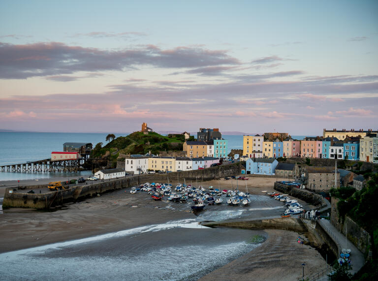 Image of Tenby Harbour beach, colourful houses and the lifeboat station.