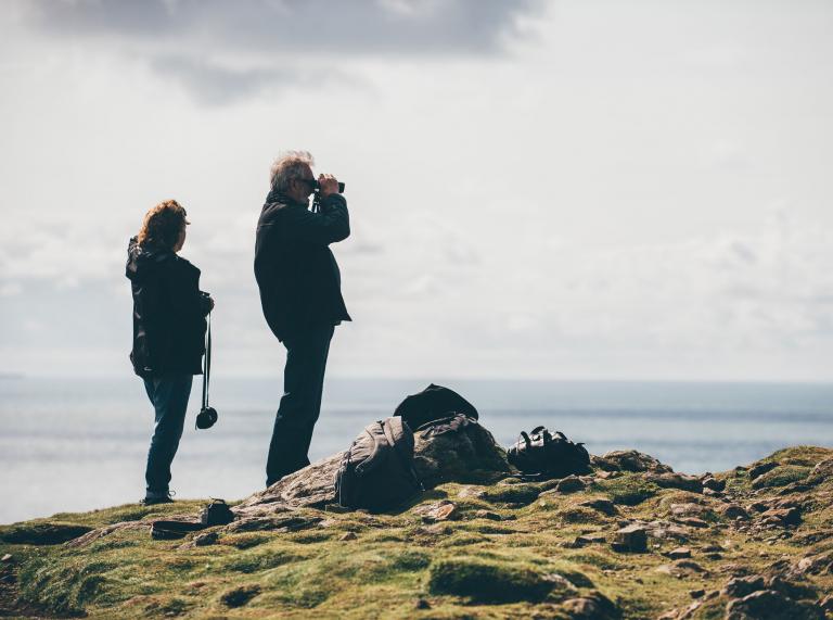 Man with binoculars on Skomer Island, Pembrokeshire