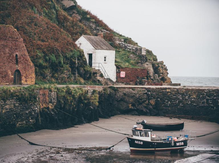 Fishing boat moored up at low tide in Porthgain.