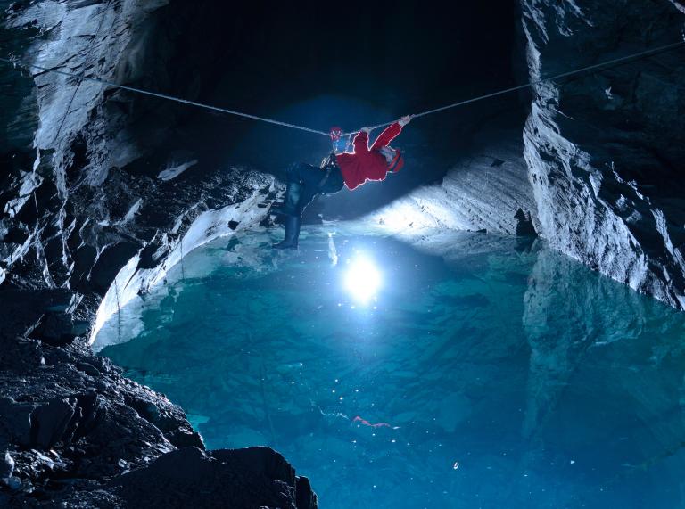 Person on zip wire in a cave over water