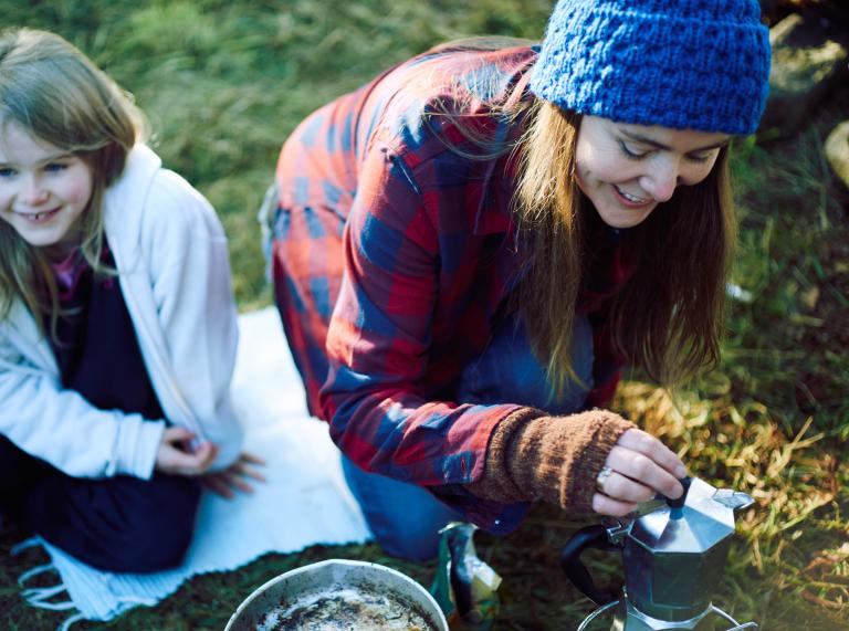 two females and boiling kettle in wilderness.