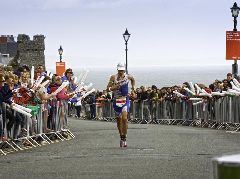 Ironman Wales competitor running on road above South Beach, Tenby
