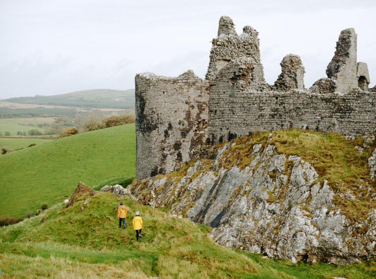 Exterior of a partially ruined castle on a hill.