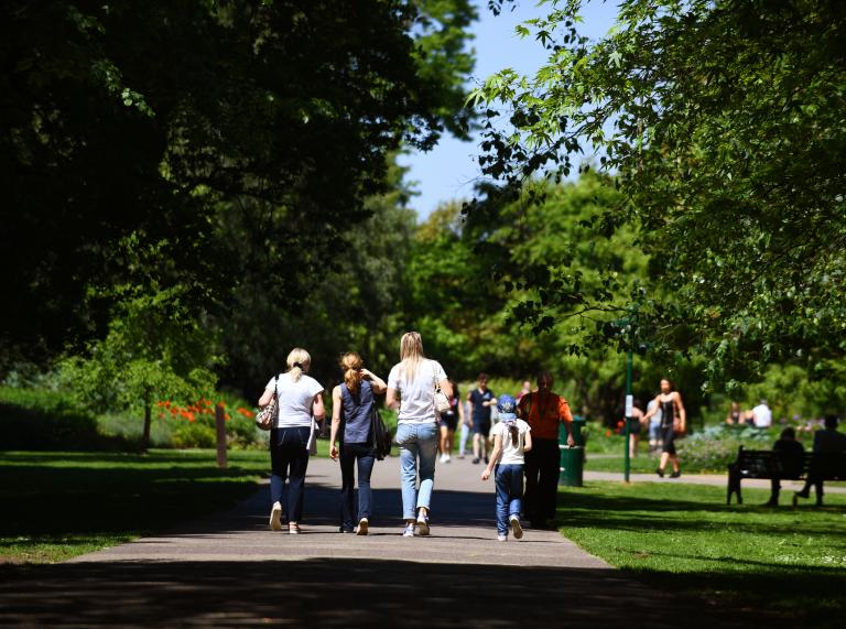Group of people walking in Bute Park, Cardiff.