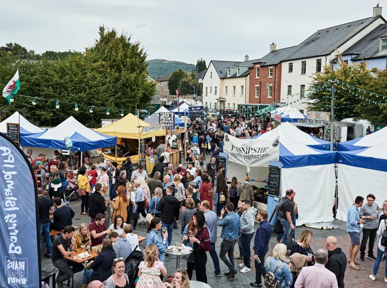 Aerial shot of people milling around market stalls and tents at Abergavenny Food Festival.
