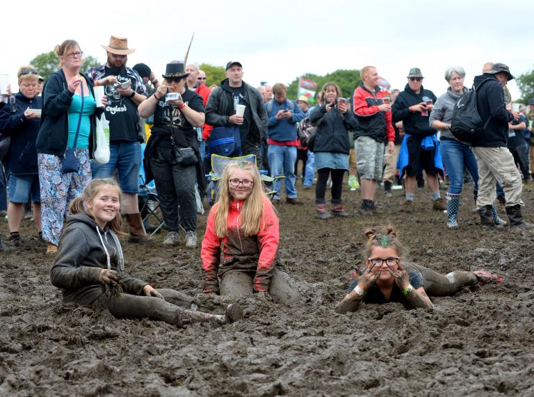 Three girls in mud at Steelhouse Festival.