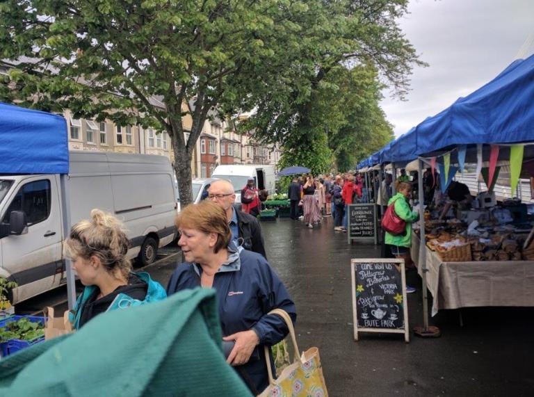 outdoor market stalls and shoppers in rain