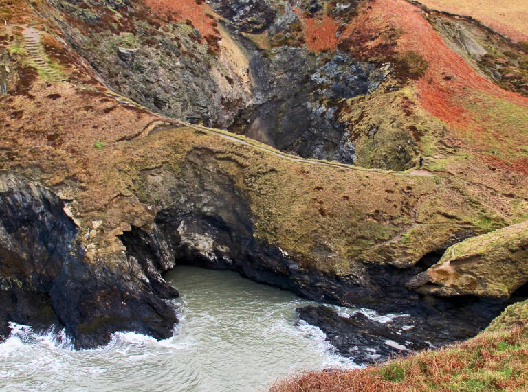 autumn colours on cliffs with caves and sea.
