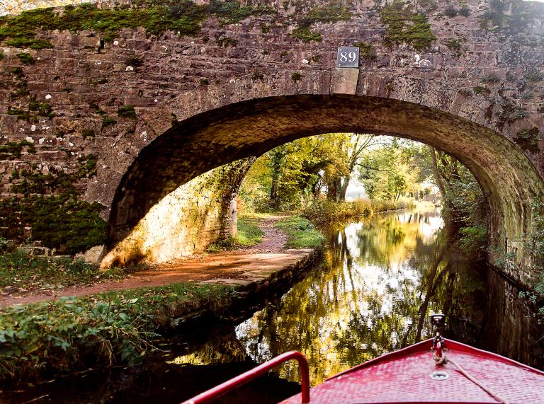 View from a narrowboat approaching a bridge.