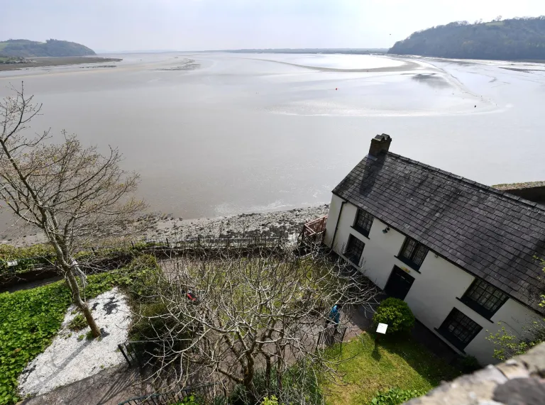 Ein weißes Haus und ein Garten mit Blick aufs Meer.