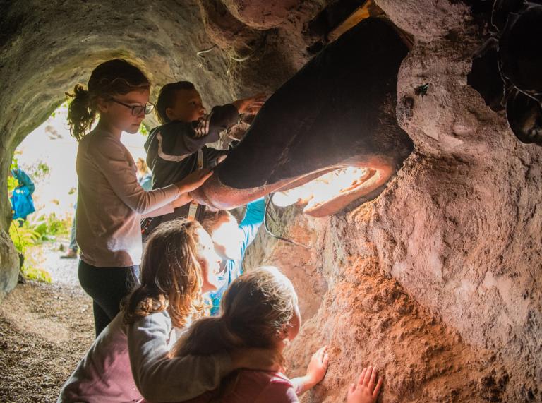 Children meeting a giant mole in a cave tunnel.