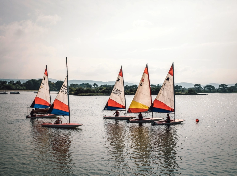 Five sailing boats on a lake.