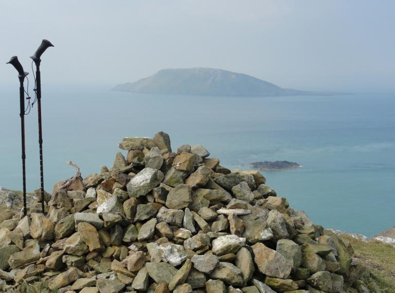 Blick nach Bardse Island von einem Steinhaufen aus und mit zwei Wanderstöcken daneben.