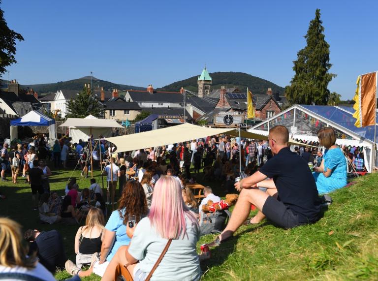 People sitting on grass at a food festival