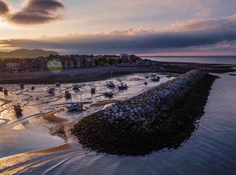 A seaside town and harbour at sunset.