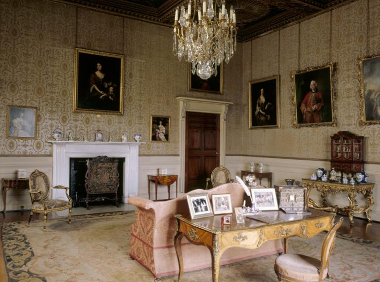Formelles Wohnzimmer von Chirk Castle mit Schreibtisch, Kamin, Kronleuchter und Couch.