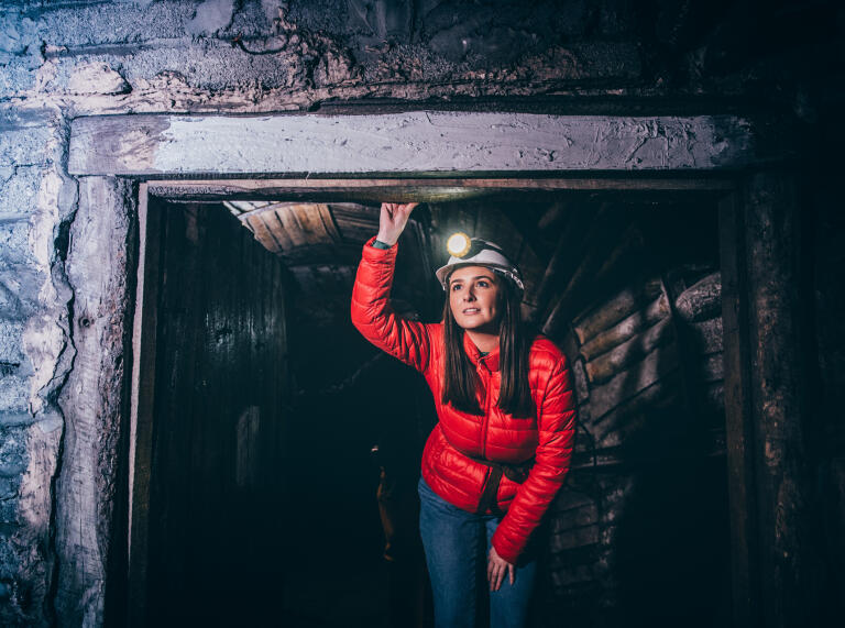Frau mit Helm und Stirnlampe in einer Mine, Big Pit National Coal Museum.