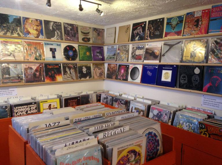records on display on wall and in boxes.